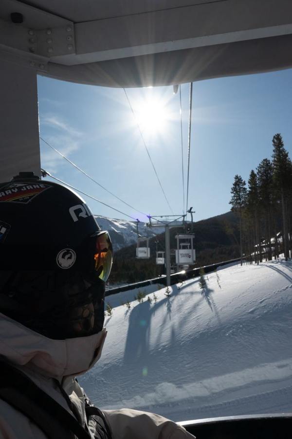 A person looking from a gondola cabin toward the snow.