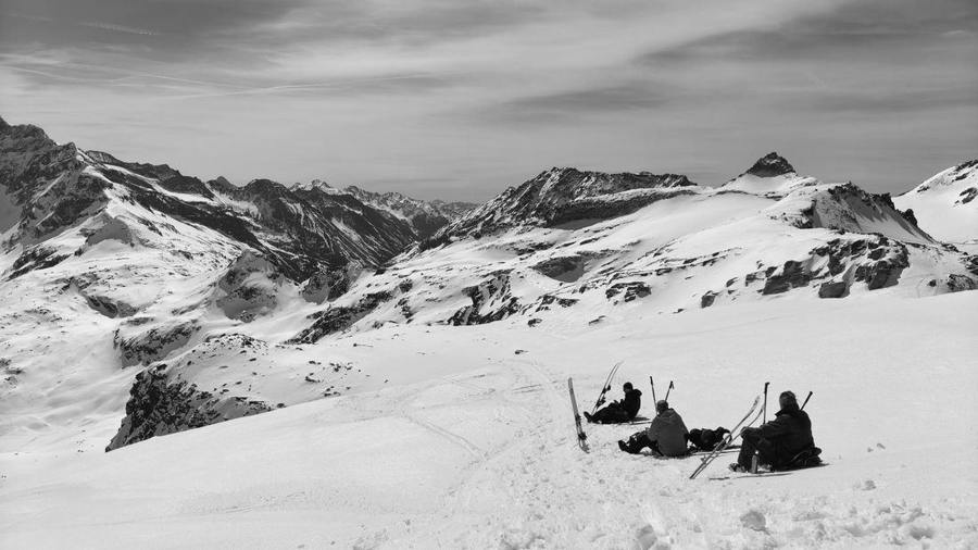 Winter sports participants taking a break on a snowy mountain.