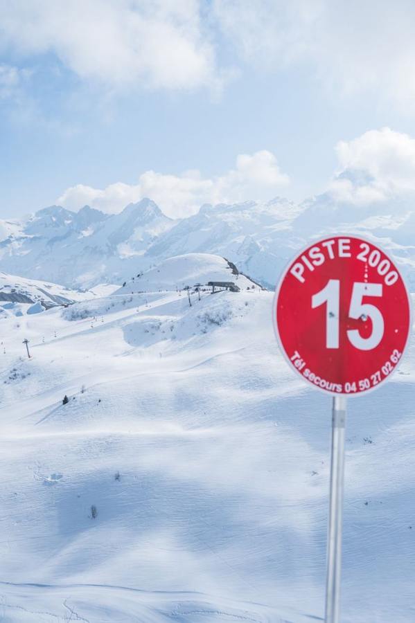 A red piste sign numbered 15 in the snow.