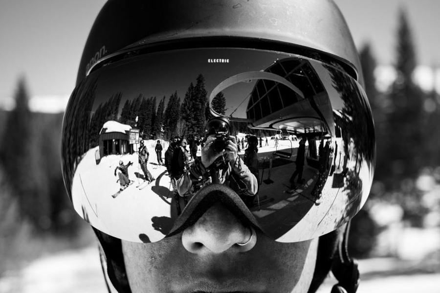 Close-up of mirrored ski goggles reflecting a winter landscape.