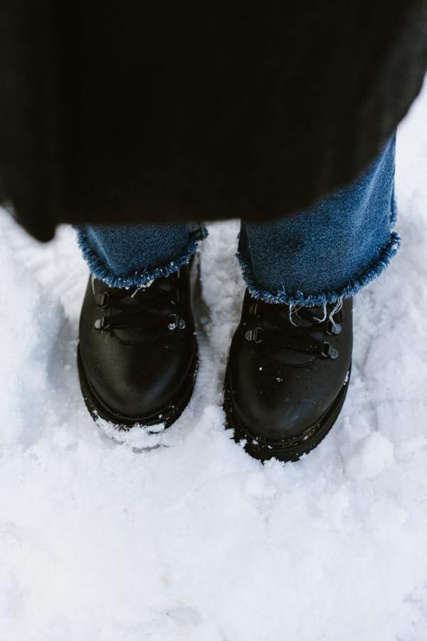 Black winter boots stand in the snow.