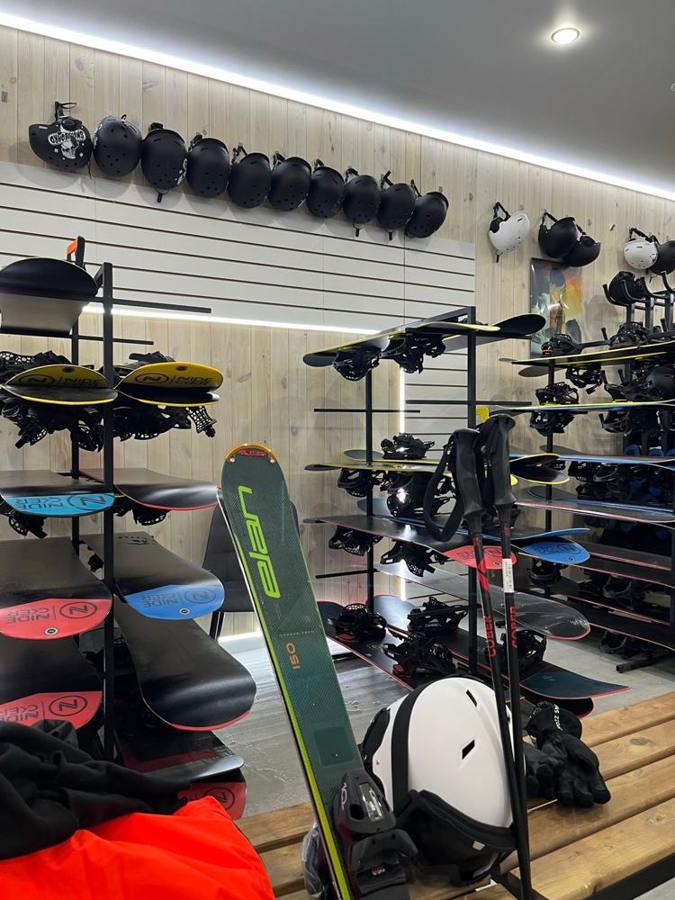 Ski equipment and helmets are displayed inside a winter sports shop.